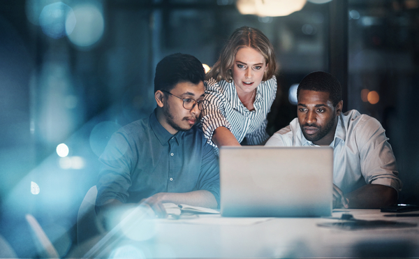 shot of three young business people working together on a laptop in their office late at night