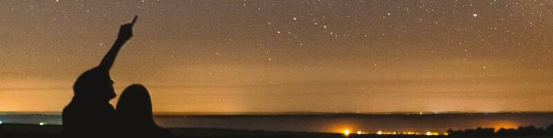 A man points at stars in the sky
